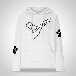White hoodie with black line art of a dog and paw prints on a white background