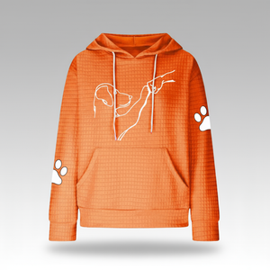 Orange hoodie with white paw prints and a dog outline on a gray background