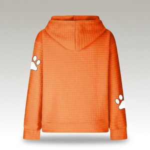 Orange hoodie with white paw prints on sleeves against a gray background
