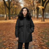 Woman wearing a black coat with fur trim in an autumn park.