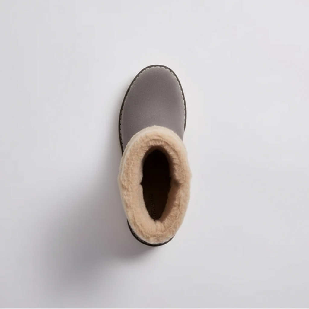Gray winter boot with beige fur lining on a light gray background
