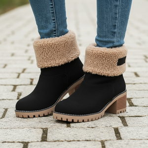 Black ankle boots with beige fleece lining worn on a paved surface