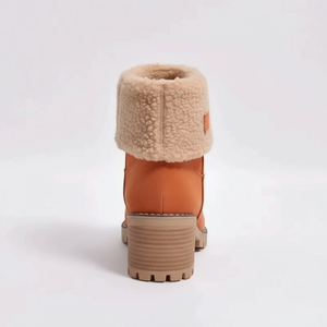 Tan winter boot with fur lining on a white background