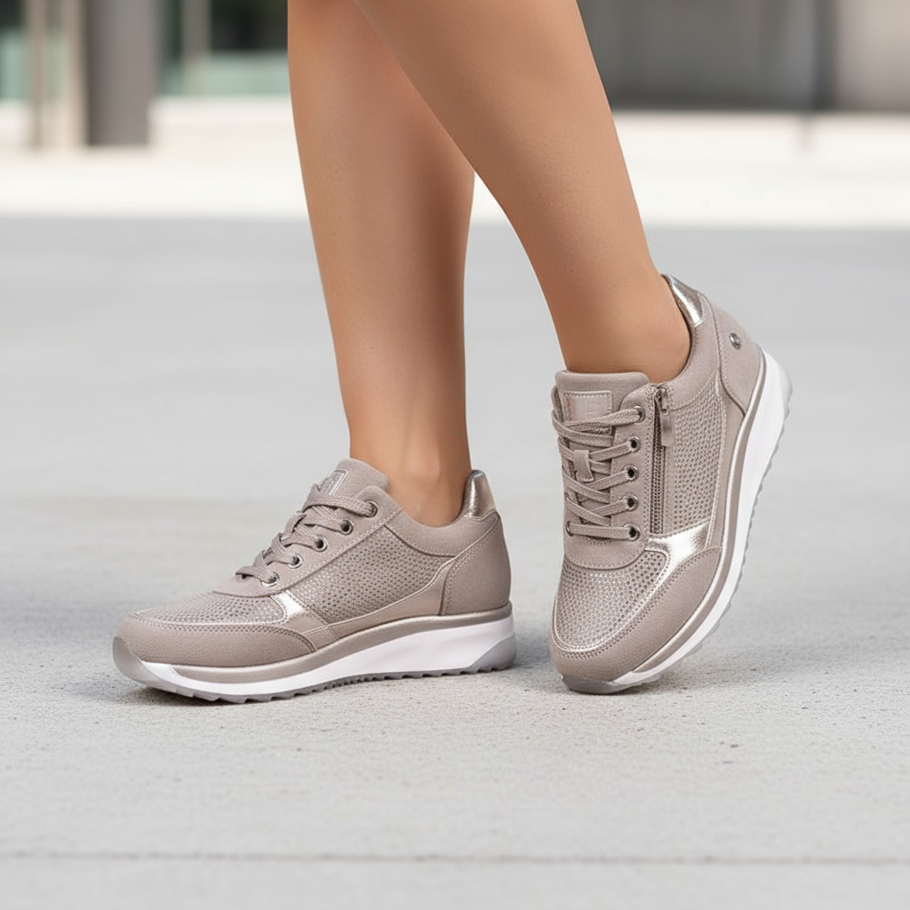 Beige sneakers worn by a person on a light gray surface