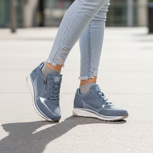 Blue sneakers worn with light blue jeans on a blurred street background