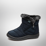 Navy blue winter boot with gray fur trim on a light gray background