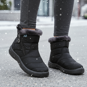 Black winter boots with fur lining worn on a snowy ground