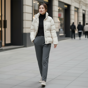 Woman in a white puffer jacket walking on a city street.