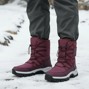Maroon winter boots with gray pants on a snowy ground
