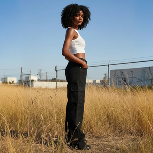 Woman standing in a field of tall grass with a clear blue sky.