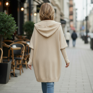 Woman wearing a beige cardigan and white crop top walking on a city street.