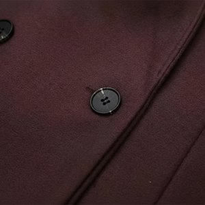 Close-up of a dark purple fabric with a button on a white background