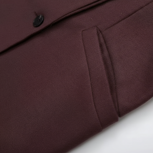 Close-up of a burgundy coat with a button on a white background