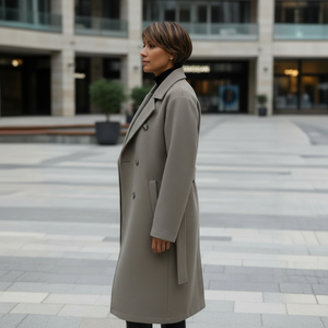 Woman wearing a long coat standing in an urban setting