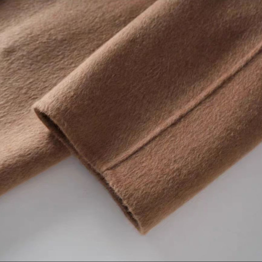 Close-up of brown fabric with a visible seam on a light gray background