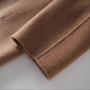 Close-up of brown fabric with a visible seam on a light gray background