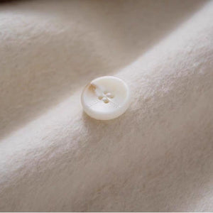 White button on a beige fabric surface