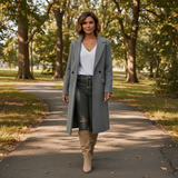 Woman in a gray coat walking on a path in a park